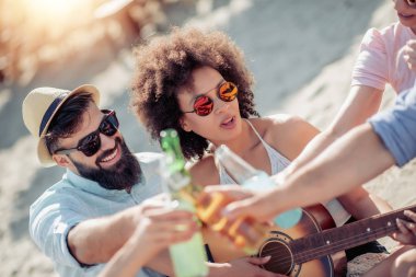 Gitarlı bir grup arkadaş sahilde eğleniyor..