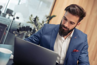 Modern ofis bilgisayar üzerinde çalışan genç işadamı.