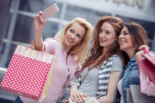 Üç güzel genç kadın akıllı telefon ile bir selfie alarak güneş gözlüğü.