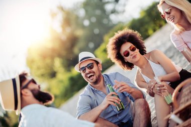 Mutlu arkadaşlar eğlenmeye sahilde günbatımı.