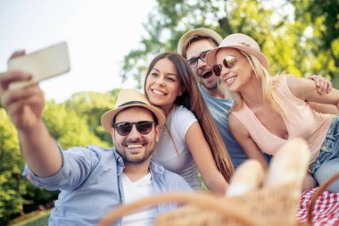 Mutlu genç arkadaşlarım parkta piknik. Onlar birlikte tüm mutlu,.