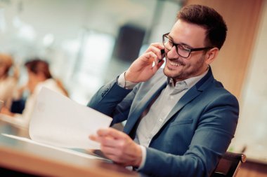 Modern ofis yakışıklı gülümseyen emin işadamı portresi.