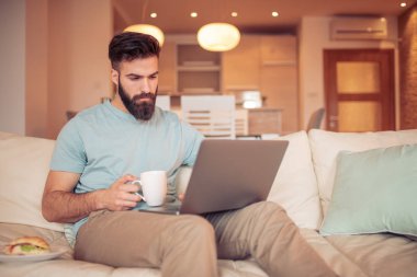 Ev ofisindeki çalışan genç adam. İnsanlar, iş, ev ve ofis kavramı.