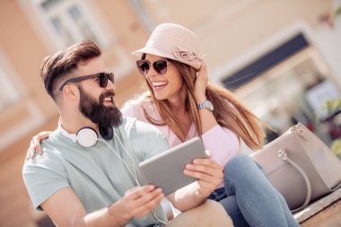 Açık havada eğleniyor, tablet kullanarak genç çift.
