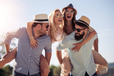 Mutlu erkek arkadaşlarını batımında sahilde piggybacking..