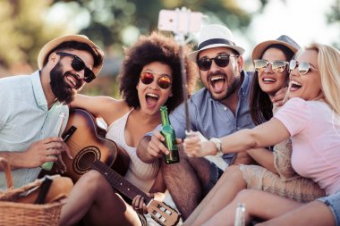 Arkadaşlar eğlenmeye sahilde gitar ile neşeli grup.