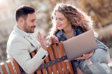 Güzel romantik çift dizüstü bilgisayar ile şehrin geri kalan sahip. Birbirlerinin şirket zevk.