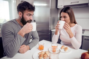Mutfakta oturuyor ve kahvaltı genç Çift.