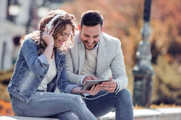 Şehrin bankta oturmuş ve müzik seven Çift.