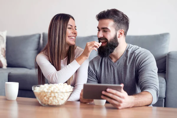 Mutlu çift ekrandaki bir birlikte okudukları gibi gülümseyen bir tablet üzerinde sörf.