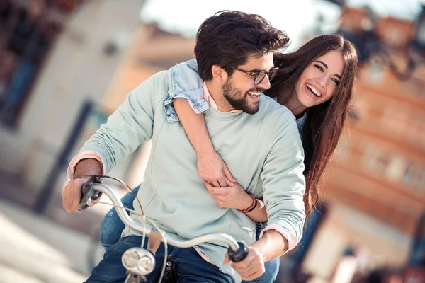 Şirin çift bisikletle güneşli bir günde şehirde binmek..