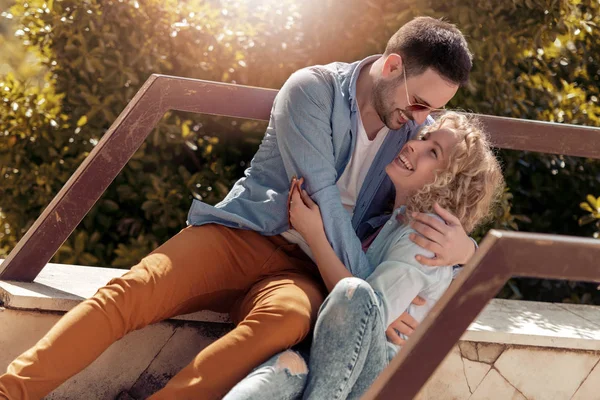 Mutlu genç çift doğada çevrilmemiş oturan aşık.