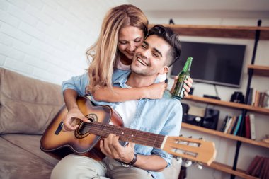 Yakışıklı adam biraz müzik gitar onun kız arkadaşı oynamak..