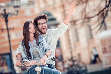 Mutlu çift için bir bisiklet mi şehirde güneşli bir günde binmek..