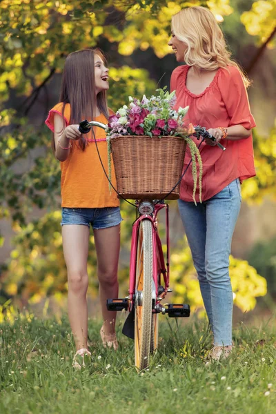 美しい母と娘 公園で楽しく自転車に乗って — ストック写真