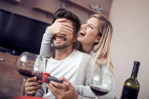 Kadın vermek adam romantik toplantı sırasında bir hediye kapalı gözlerini eliyle.