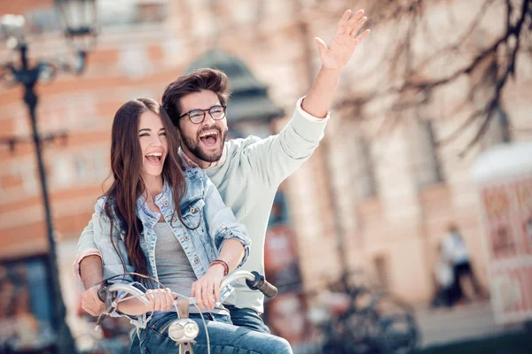 Mutlu çift için bir bisiklet mi şehirde güneşli bir günde binmek..