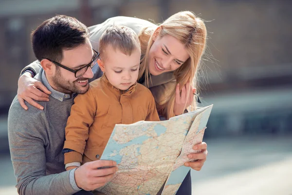 Family looking at map on a city street.