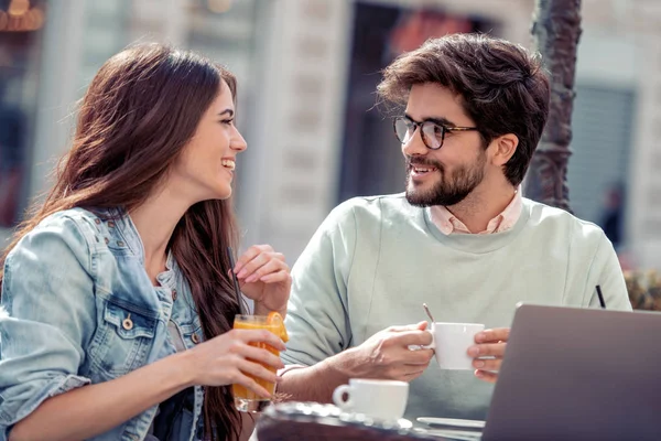 カフェのカップル前に座って 一緒に時間を過ごす コーヒー オレンジ ジュースを飲んで ラップトップを使用して — ストック写真
