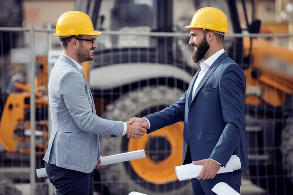 İnşaat alanında el sıkışan iki iş ortakları.