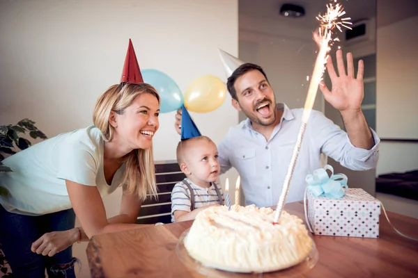 Birthday. Little boy blows out candles on birthday cake at party. Happy family celebrating birthday.