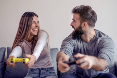 Mutlu çift birlikte oturma odasında ve video oyunları oynarken.