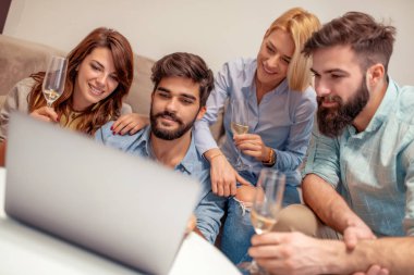 Birlikte kanepede oturan ve laptop komik video izlerken arkadaşlar.