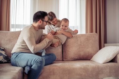 Neşeli genç aile evde iyi vakit geçiriyor.