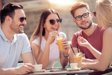 Gülümseyen ve Sokak kafede oturan arkadaşlar 