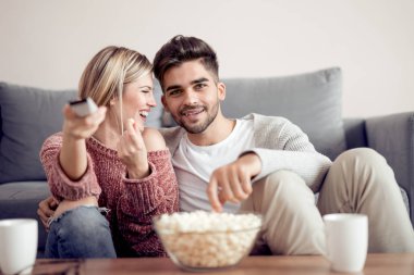Mutlu genç Tv izlerken patlamış mısır ile çift. .