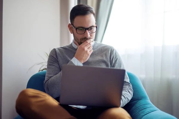 Bonito Homem Usando Laptop Enquanto Sentado Poltrona Casa — Fotografia de Stock