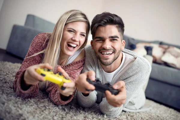 Young couple playing video games in living room