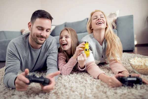 Happy family playing video game on floor at home.