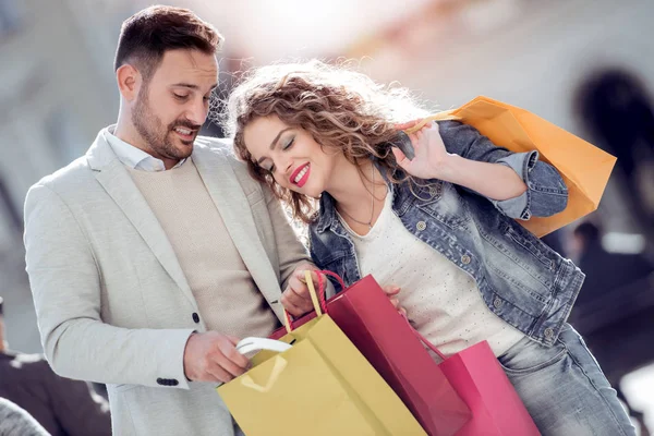 年轻快乐夫妇与购物袋在销售期间 — 图库照片