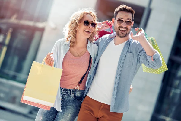 幸せな若いカップル ショッピング バッグ販売中 — ストック写真