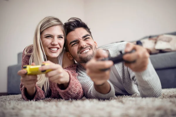 Young couple playing video games in living room