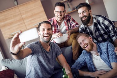 Neşeli grup selfie alarak ve futbol maçı izlerken arkadaşıyla.