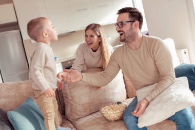 Neşeli genç aile evde iyi vakit geçiriyor.