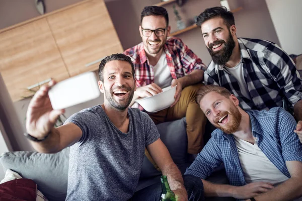 Neşeli grup selfie alarak ve futbol maçı izlerken arkadaşıyla.