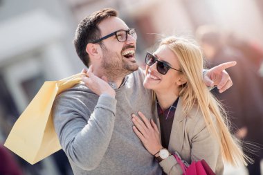 Şehirde alışveriş sonra genç çift gösteren resim.