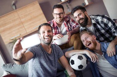 Evde eğlenmek, selfie alarak ve futbol maçı izlerken arkadaşlar neşeli grup.