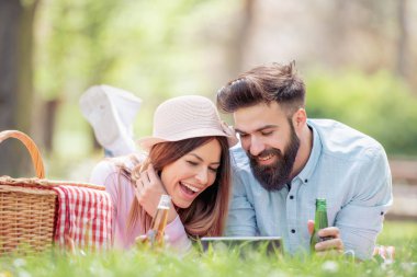 Mutlu çift birbirlerine gülümseyen güneşli bir günde bir piknik üzerinde. İnsanlar, sevgi, mutluluk ve doğa kavramı.