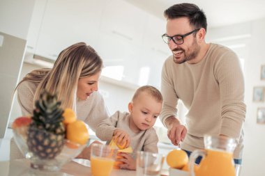 Neşeli genç aile portakal suyu birlikte yapma.
