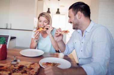 Ev yapımı pizza birlikte mutfağa yemek çift gülümseyen genç.
