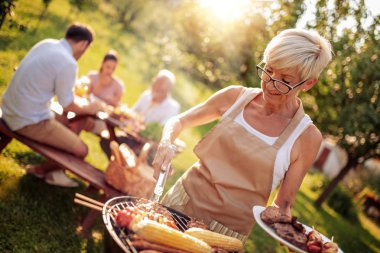 Aile parkta barbekü yapıyor. Boş zaman, yemek, aile ve tatil konsepti..