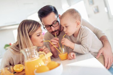 Neşeli genç aile portakal suyu birlikte yapma.