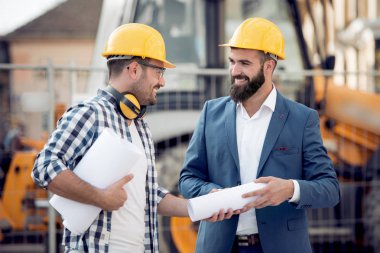 Ayrıntılı planının inşaat sahasında iki mühendislere.