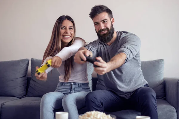 Casal Feliz Sentados Juntos Sua Sala Estar Segurando Controladores Rindo — Fotografia de Stock