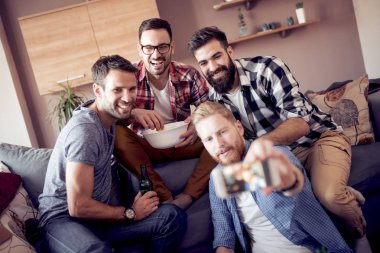 Evde eğlenmek, selfie alarak ve futbol maçı izlerken arkadaşlar neşeli grup.