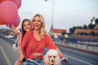 Anne ve kızı birlikte eğleniyor, Bisiklete binmek.